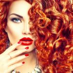 Beauty young woman with curly red hair, perfect make up and mani